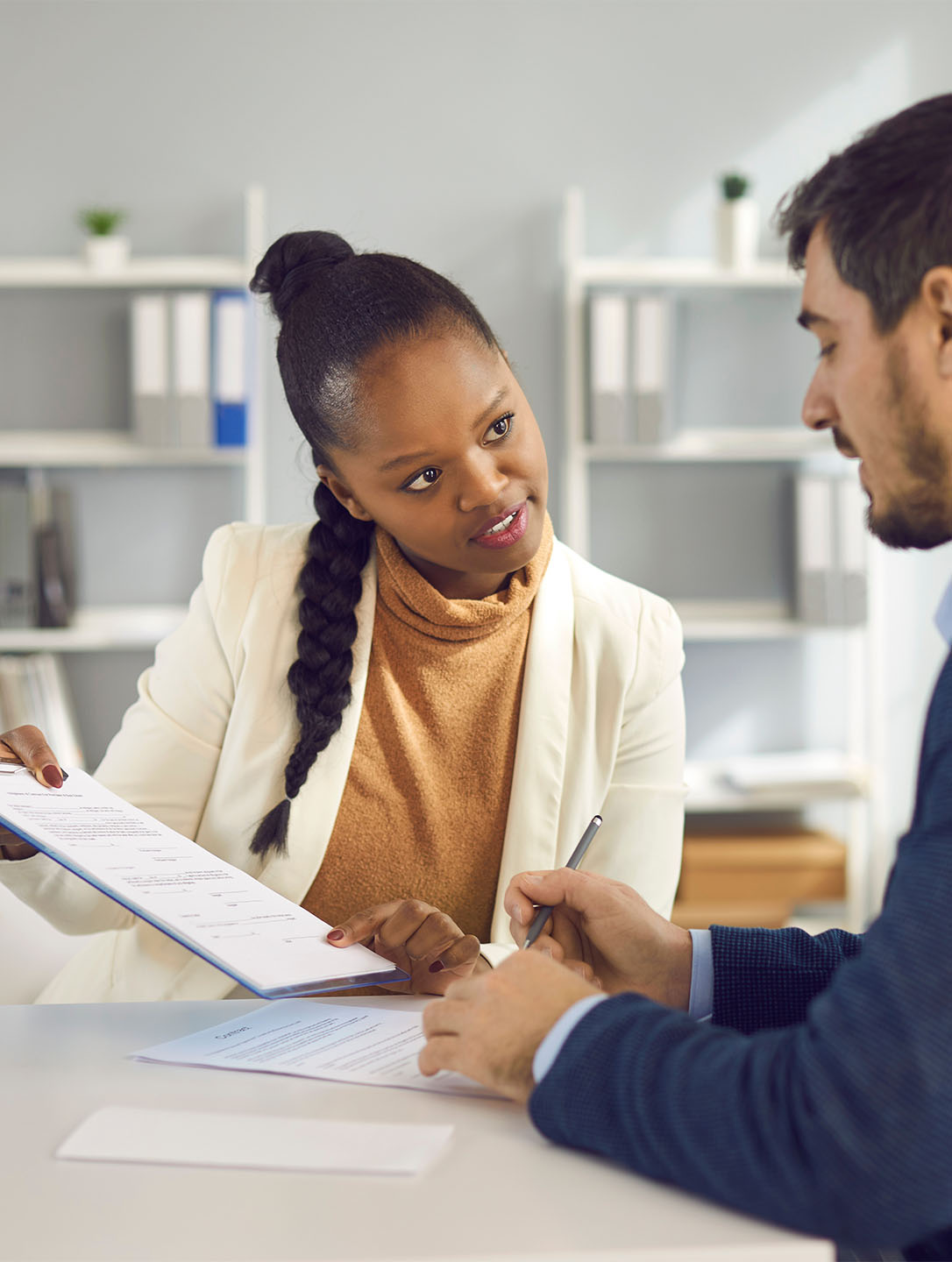 Afro american solicitor pointing at insurance contract showing client to sign